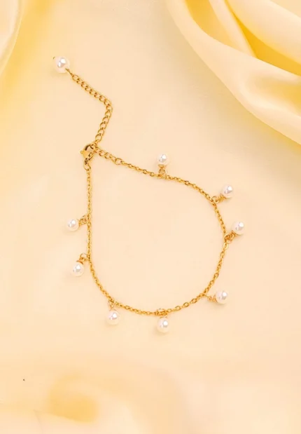 Elegant adjustable curb chain bracelet in a gold-tone finish, featuring a curved metallic wire centerpiece with a dangling spherical charm and a secure spring ring clasp.