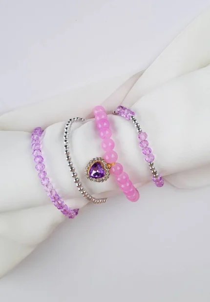 Pack of four beaded bracelets in lilac and silver tones. Each bracelet has a glossy or faceted finish and smooth elastic fit.