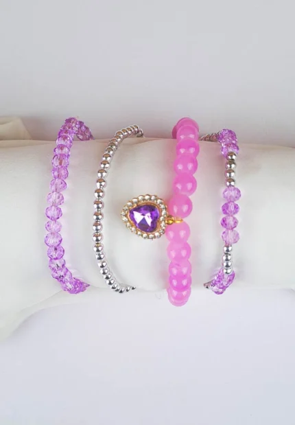 Pack of four beaded bracelets in lilac and silver tones. Each bracelet has a glossy or faceted finish and smooth elastic fit.