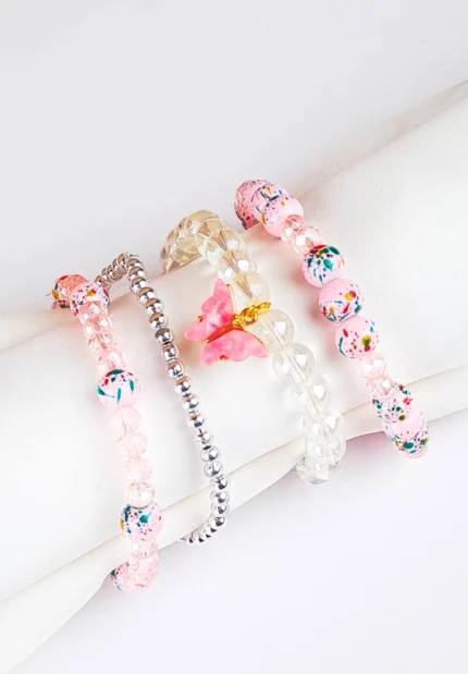 Pack of four pastel pink and clear glass beaded stretch bracelets, including a butterfly charm,
