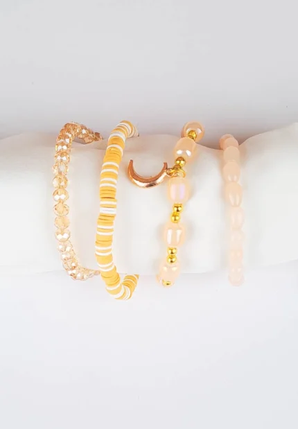 Pack of four neutral and gold beaded stretch bracelets, one with a moon charm.