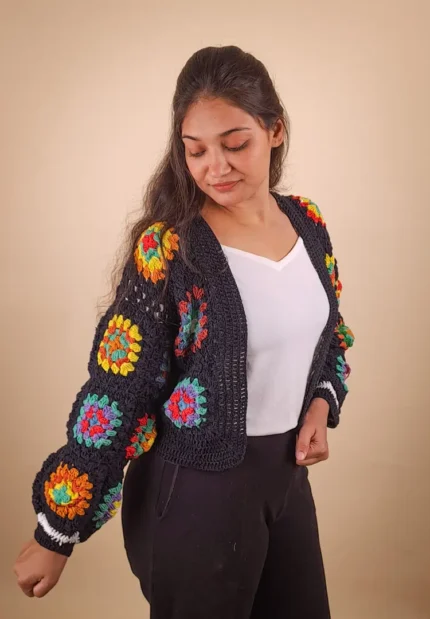 Women’s coral-black crochet cardigan with intricate floral patterns.