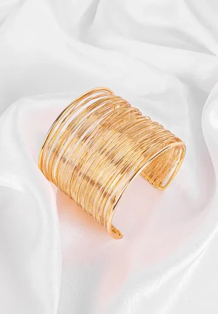 Open-ended cuff bracelet made from layered metallic wires with a sculptural polished finish.