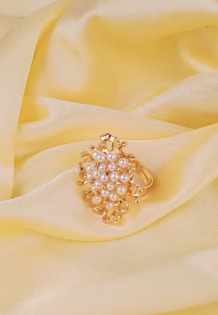 Elegant adjustable band ring with clustered pearls and intricate openwork design, exuding a refined statement style.