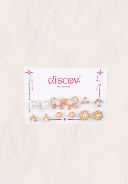 Collection of five pairs of gold-toned stud earrings, including bow shapes, textured flower studs, simple pearl domes, tiny gold balls, and clustered micro-bead designs.