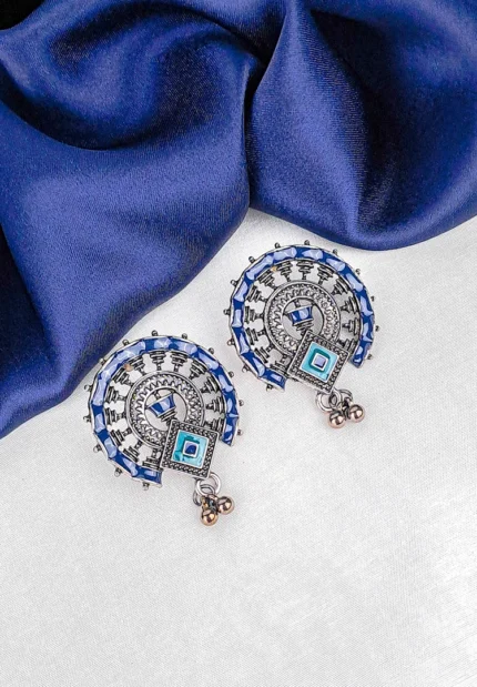 Oxidized silver half-moon stud earring with blue, brown, and green enamel detailing and a small hanging ghunghroo.