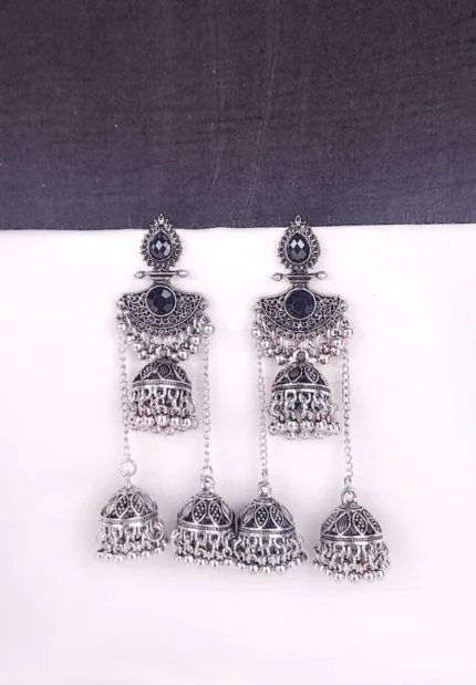 Traditional oxidized jhumka earrings featuring black stone studs and layered triple jhumkis.