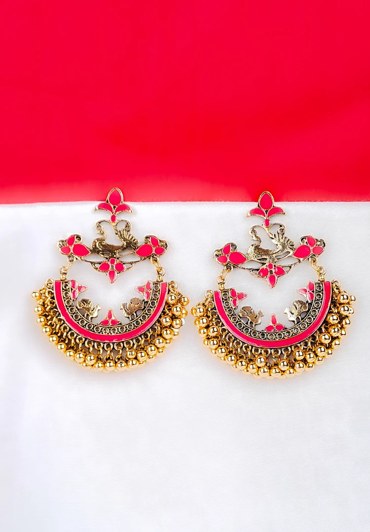 th (23) Gold-toned crescent-shaped earring with pink enamel, peacock motifs, floral detailing, and hanging ghunghroo beads.