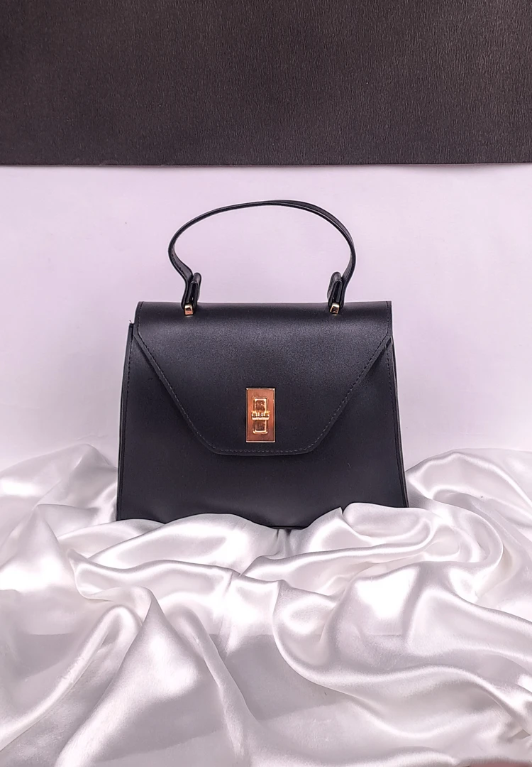 th (45) Black sling bag with structured flap design and gold twist-lock closure, featuring an adjustable strap — chic everyday bag