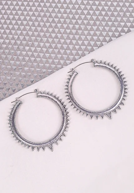 "Silver spiked hoop earrings with beaded edging, polished textured finish, and latch‑back closure. "