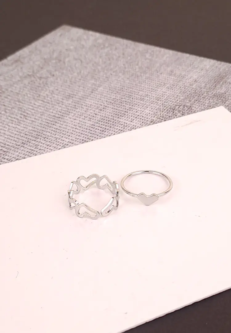 th (94) An open, adjustable silver-toned ring featuring a repeating, delicate pattern of interconnected heart shapes, another with heart in middle ideal for stacking.