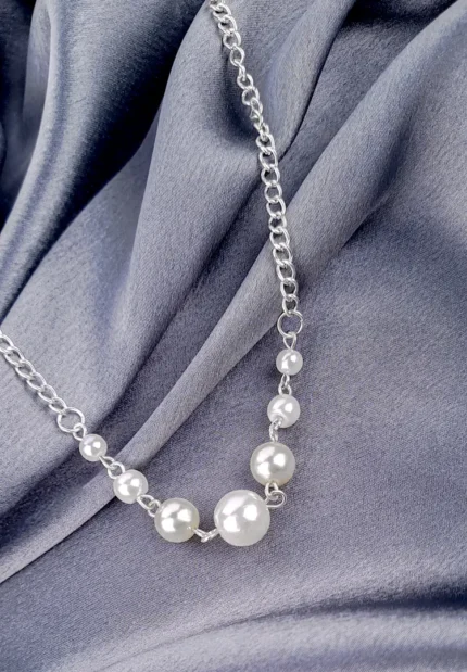 A silver-toned curb chain necklace featuring a central cluster of three large and four smaller faux pearls arranged in a symmetrical, graduating pattern.