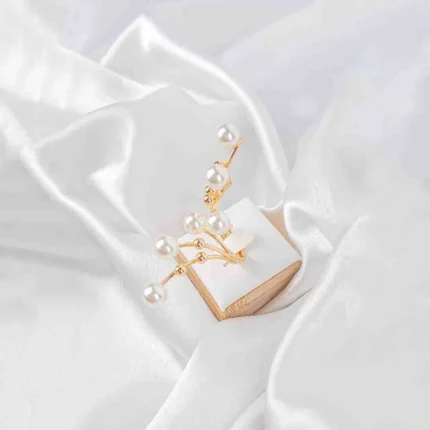 Multi-band adjustable ring with delicate pearl accents on slender metallic branches, polished to a refined finish.