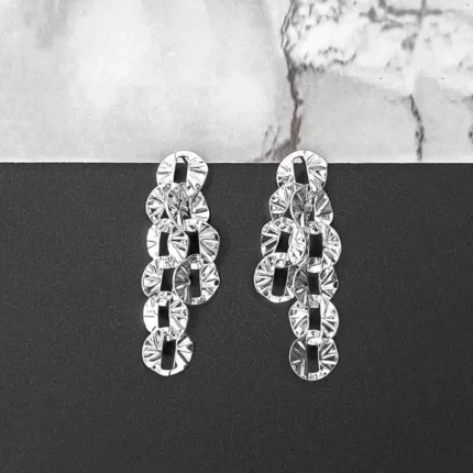 Silver drop earrings with sculpted textured discs and push-back closure, featuring a contemporary geometric design.