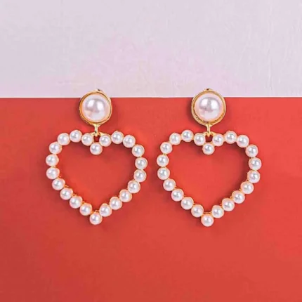 Heart-shaped pearl hoop earrings with gold accents and large pearl studs.