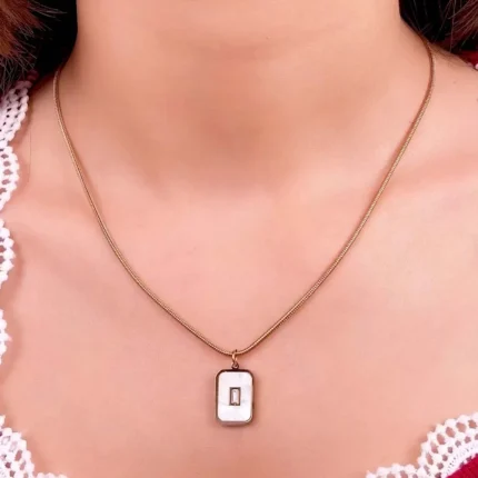 "Rose gold necklace with rectangular cutout pendant in stainless steel. "