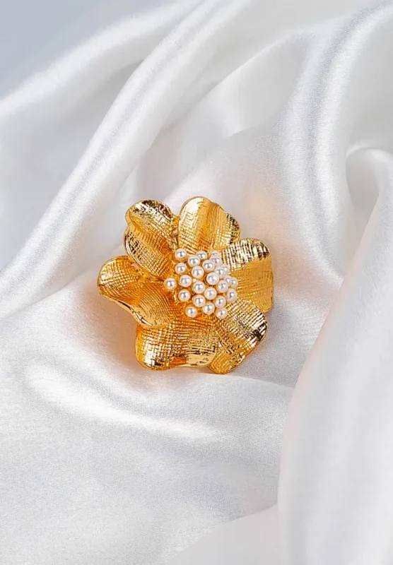 Gold-tone flower ring with textured petals and pearl cluster center, adjustable fit.