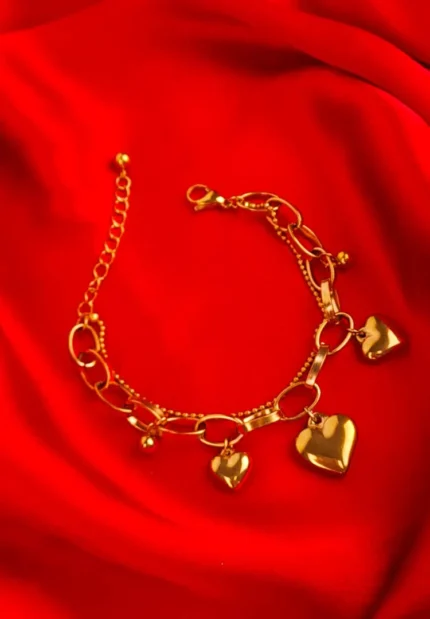 Gold drop earrings with puffy heart charms and polished finish.