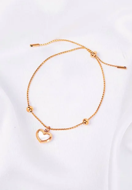 Gold adjustable chain bracelet with open heart charm, bead accents, and slider closure.