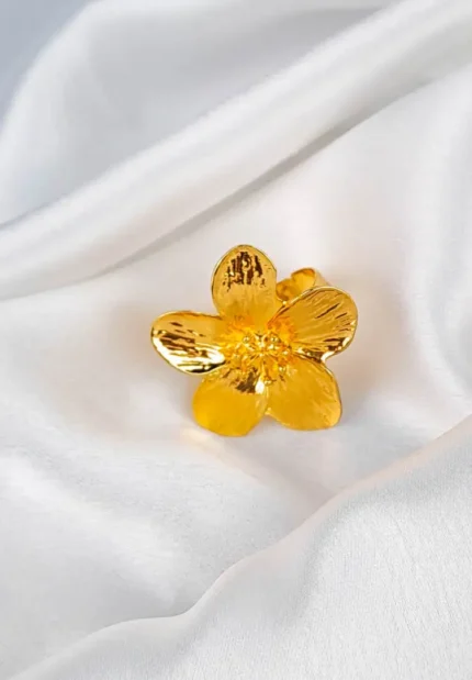 Gold-tone statement ring with textured flower design and adjustable band.