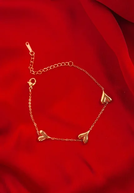  Gold chain bracelet with three puff heart charms and adjustable lobster clasp.