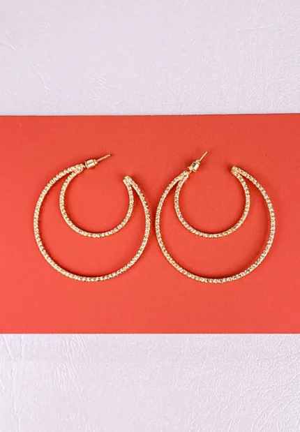 Gold layered hoop earrings with textured polished finish and push‑back closure, featuring three interlaced arcs for a sculptural look.