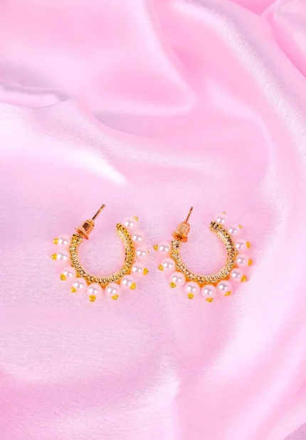 "Gold huggie hoop earrings with small white pearl drops, polished finish, and push‑back closure. "