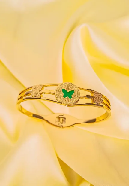 Gold bracelet with a green butterfly at the center, polished finish, and adjustable closure for a stylish and elegant look.