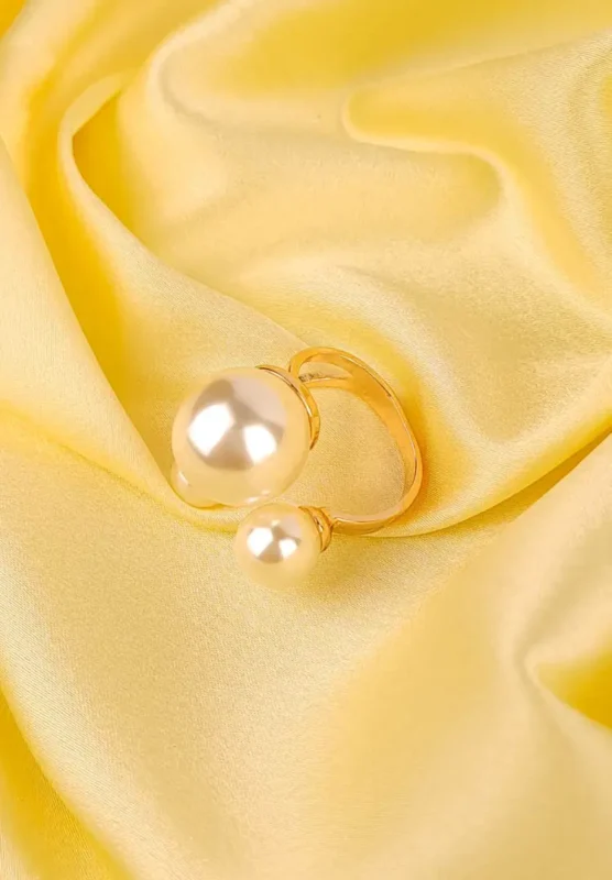 Open ring with two faux pearls of different sizes on a polished adjustable band.