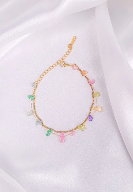 Gold bracelet with pastel gemstone drops and adjustable extender.