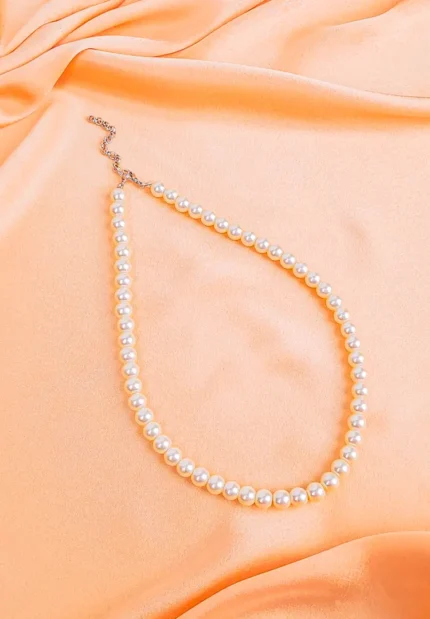 Vintage ivory pearl beaded necklace with lobster clasp, arranged in a gentle curve