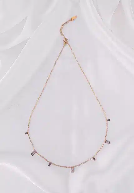 A gold-toned bracelet with a thin chain and small, dangling rectangular white gems.