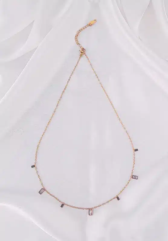 A gold-toned bracelet with a thin chain and small, dangling rectangular white gems.