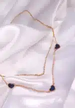 Layered gold necklace with black enamel heart pendants and lobster clasp.