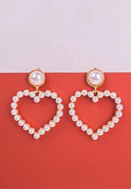 Heart-shaped pearl hoop earrings with gold accents and large pearl studs.
