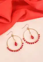 Gold hoop earrings with red crystal beads and teardrop pendant, featuring a fishhook closure.