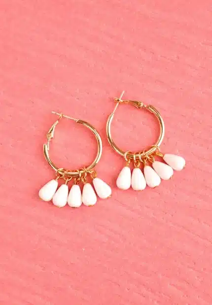 "Gold hoop earrings with white teardrop dangle beads and latch-back closure, featuring a polished finish. "