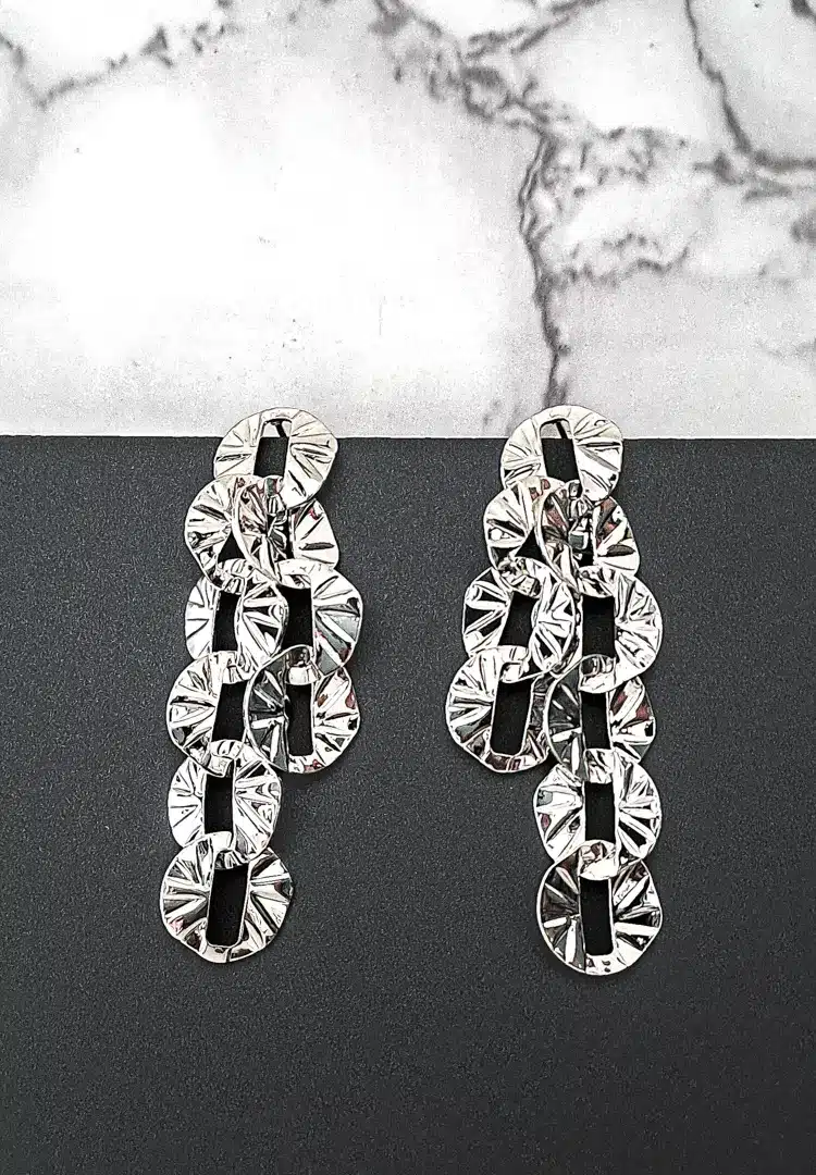 th - 2025-12-08T132238.657 Silver drop earrings with sculpted textured discs and push-back closure, featuring a contemporary geometric design.