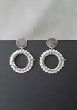 Round silver hoop earrings framed with pearls, featuring reflective studs and push-back closures.
