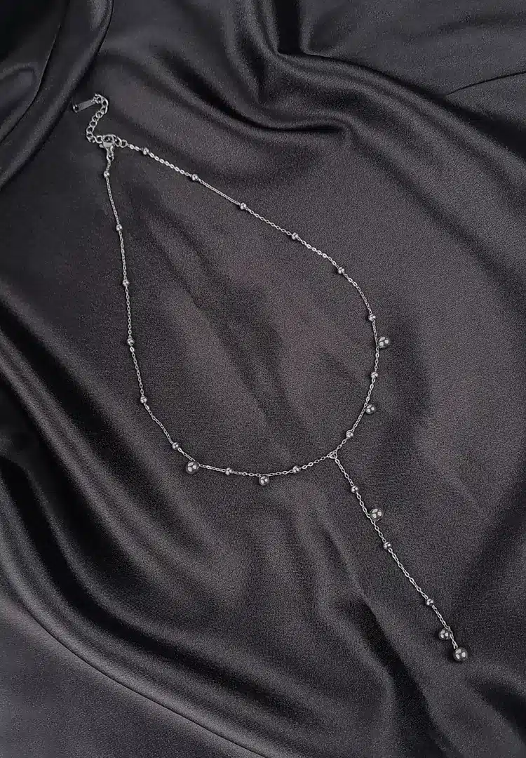 th - 2025-12-08T151625.036 Silver Y-shaped stainless steel necklace with bead details and adjustable lobster clasp.