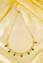 Layered gold necklace with emerald green heart charms and lobster clasp.