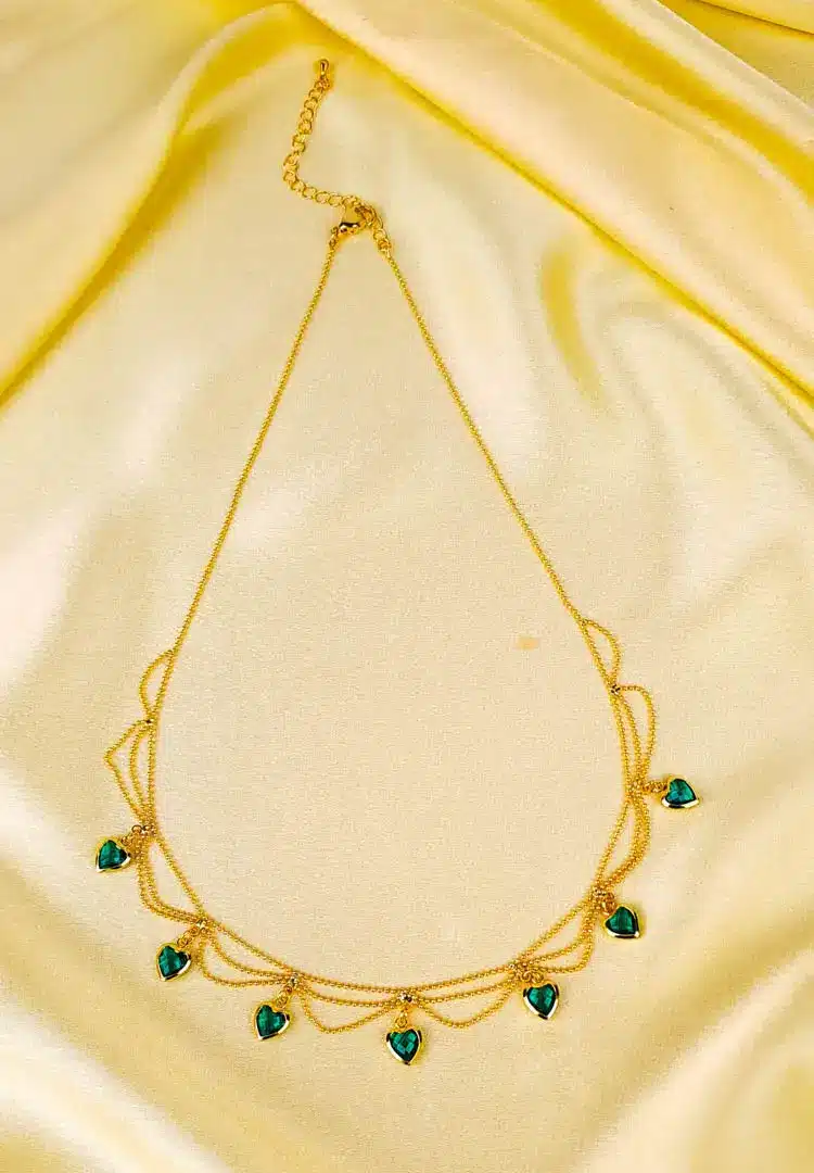 th - 2025-12-08T153458.442 Layered gold necklace with emerald green heart charms and lobster clasp.