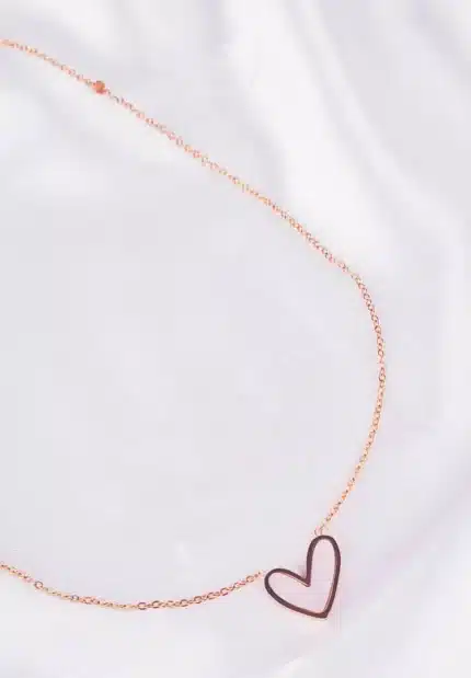 Gold chain necklace with open heart pendant and adjustable lobster clasp.