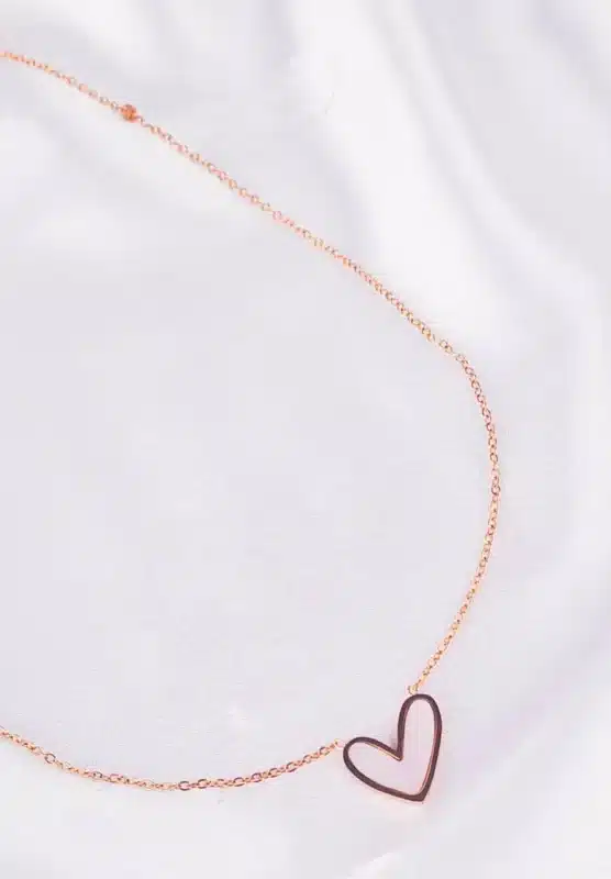 Gold chain necklace with open heart pendant and adjustable lobster clasp.